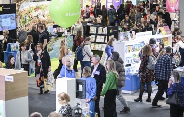 Valokuva Helsingin messukeskuksesta. Valokuvassa paljon ihmisiä kiertämässä messupisteitä. 