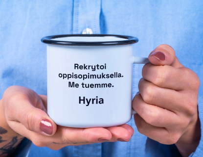 Henkilö pitelee kuppia, jossa teksti "Rekrytoi oppisopimuksella. Me tuemme. Hyria."