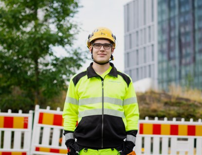 Kuva Jaakko Heinosta, hän seisoo työmaa-alueella työvaateet päällä.