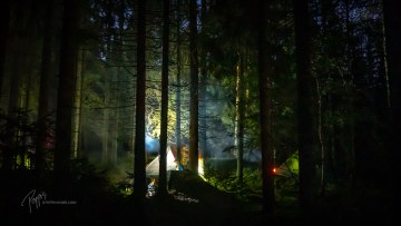 Telttailijoita pimeässä metsässä
